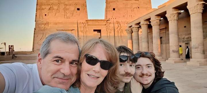 Familie macht ein Selfie vor dem sonnenbeschienenen Pylon des Philae-Tempels in Assuan