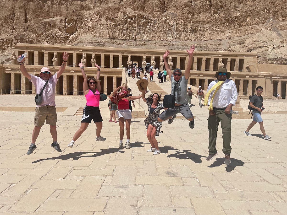 Glückliche Reisende springen vor dem Tempel der Hatschepsut in Luxor