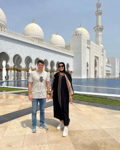Paar am Wasserbecken der Scheich-Zayid-Moschee in Abu Dhabi